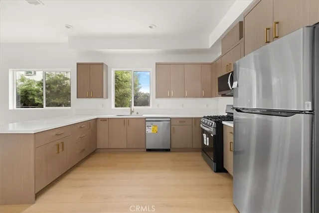 a kitchen with a sink stainless steel appliances and cabinets