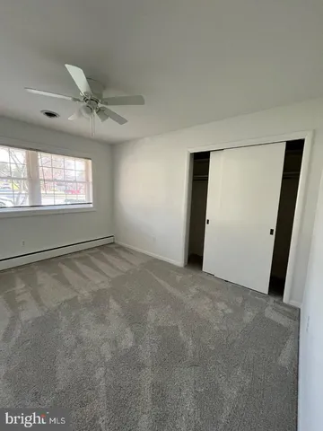 an empty room with windows and closet