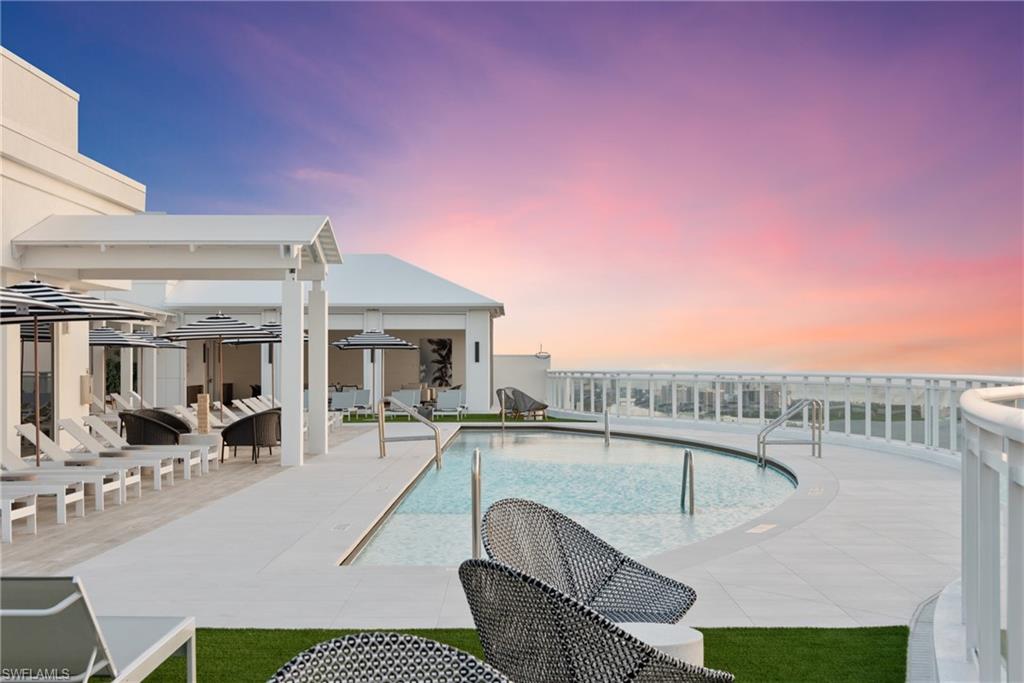 13945 Old Coast Road, Unit PH02 Naples, FL 34110 - Photo 1 of 8 a balcony with table and chairs