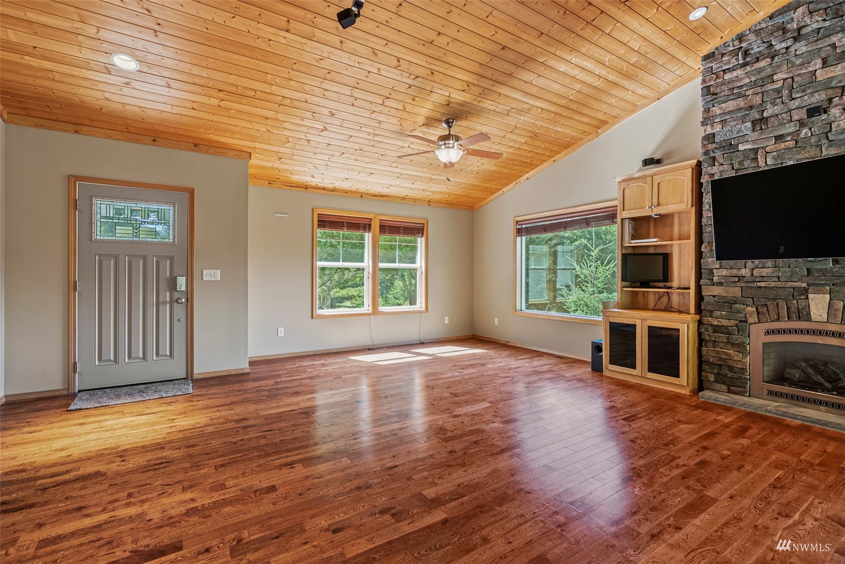 241 Puma Road Longview, WA 98632 - Photo 5 of 24 an empty room with wooden floor fireplace and windows