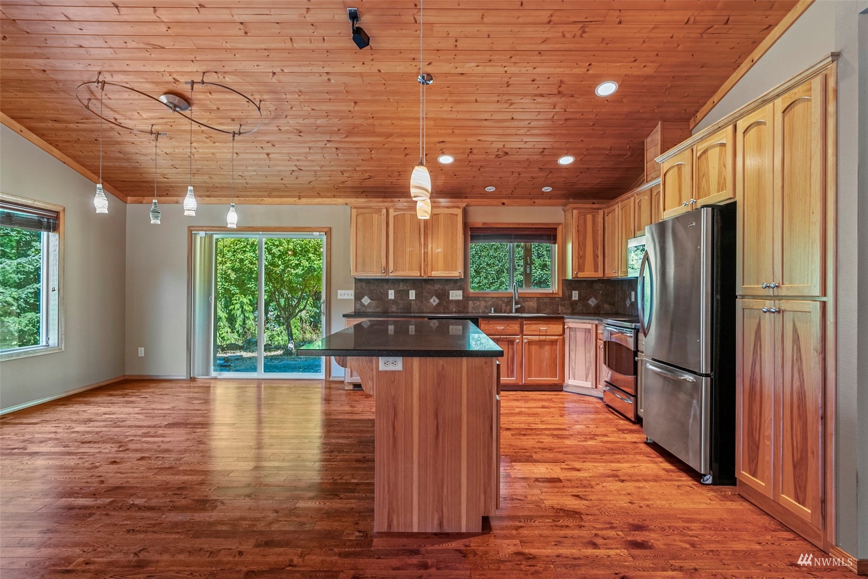 241 Puma Road Longview, WA 98632 - Photo 8 of 24 a kitchen with stainless steel appliances granite countertop a refrigerator a stove a sink dishwasher and wooden cabinets with wooden floor