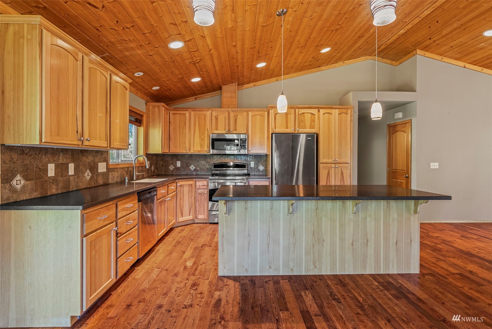 241 Puma Road Longview, WA 98632 - Photo 10 of 24 a kitchen with stainless steel appliances wooden floors wooden cabinets and sink