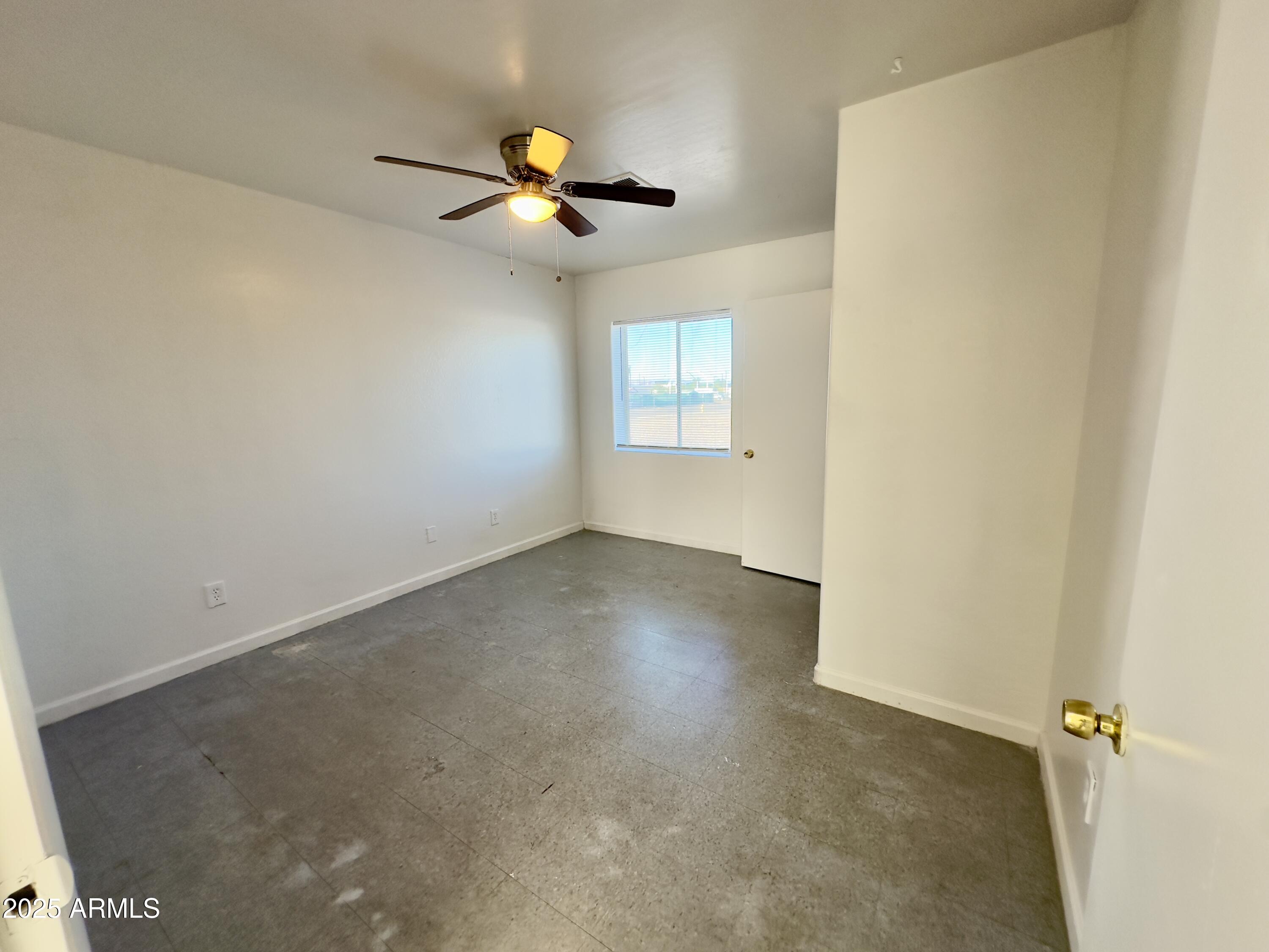 1224 East Apache Street, Unit 2 Phoenix, AZ 85034 - Photo 11 of 17 an empty room with a window and a ceiling fan