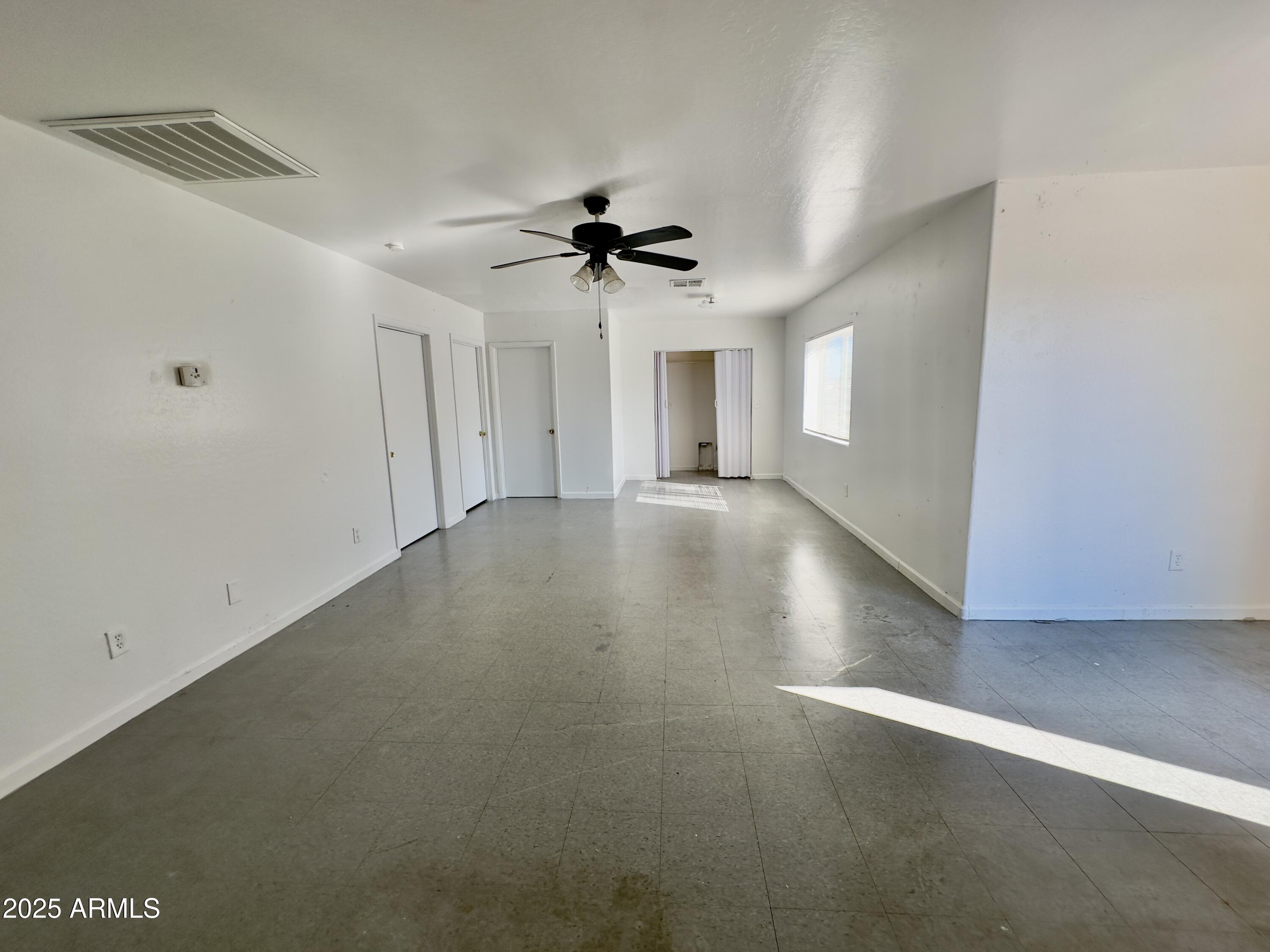 1224 East Apache Street, Unit 2 Phoenix, AZ 85034 - Photo 2 of 17 an empty room with windows and fan
