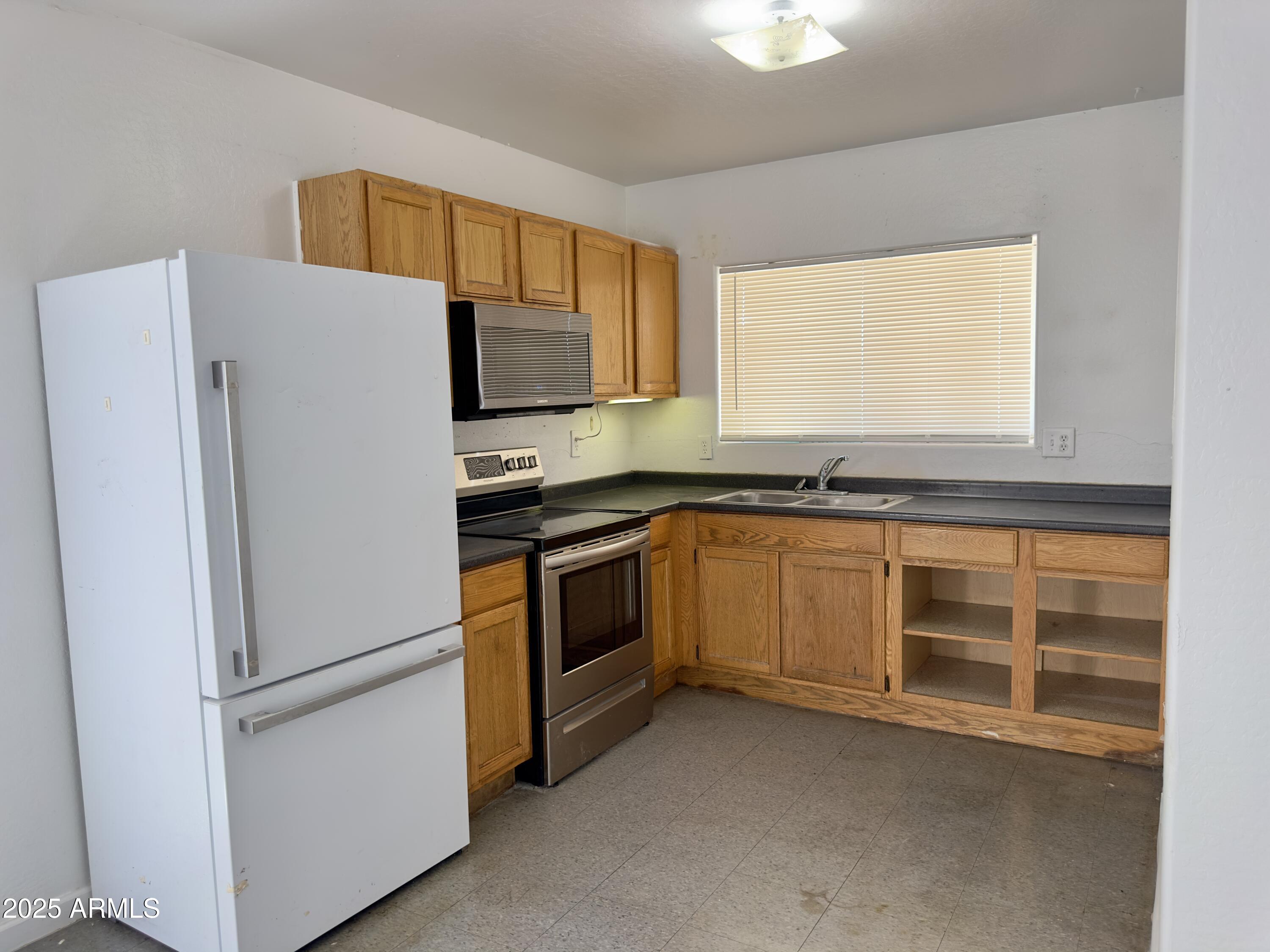 1224 East Apache Street, Unit 2 Phoenix, AZ 85034 - Photo 3 of 17 a white refrigerator freezer sitting inside of a kitchen