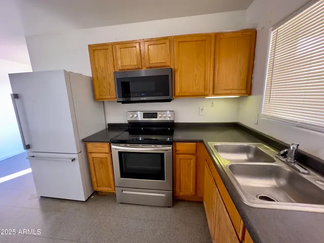 a kitchen with a sink a microwave a stove and refrigerator