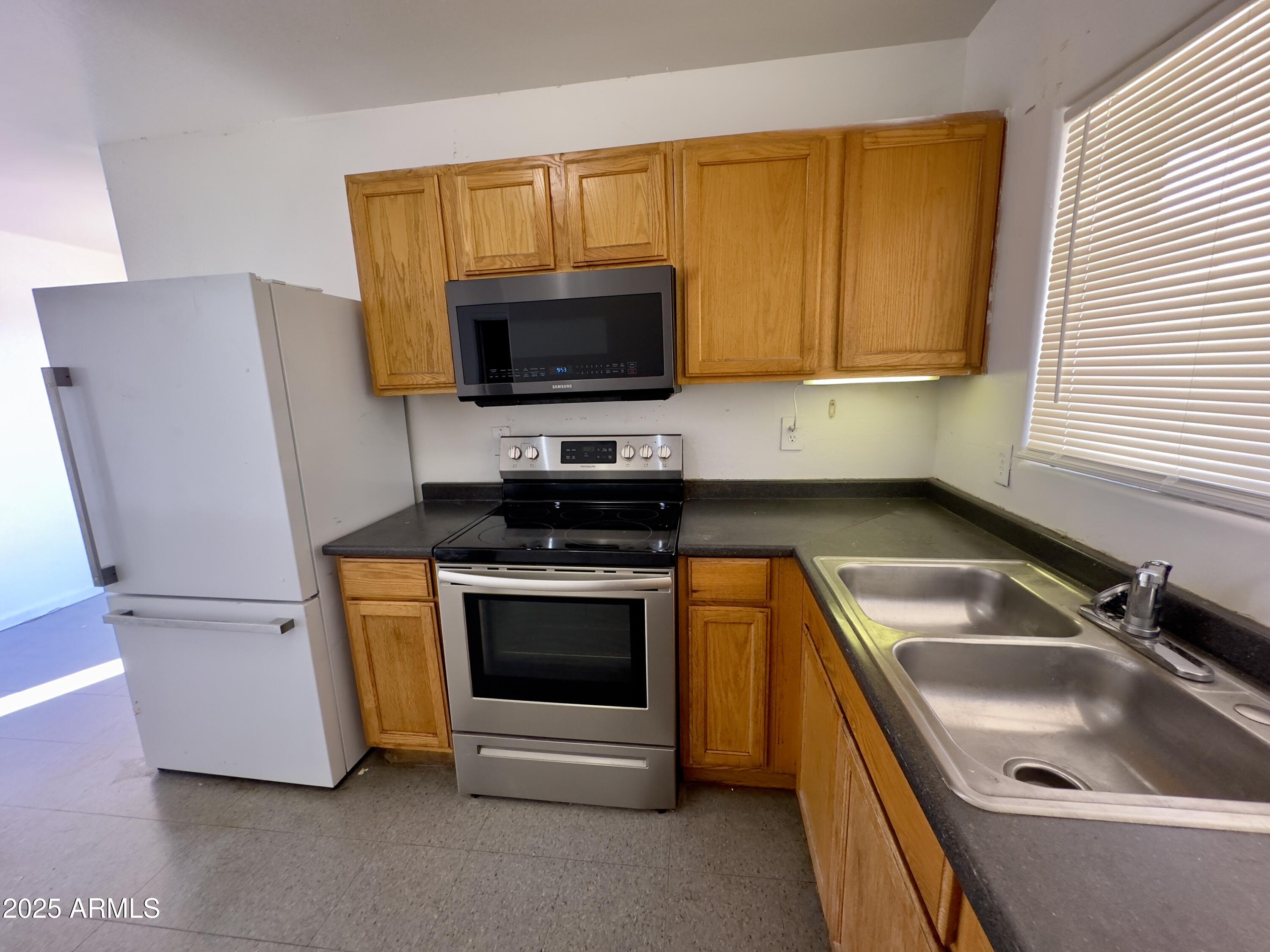 1224 East Apache Street, Unit 2 Phoenix, AZ 85034 - Photo 4 of 17 a kitchen with a sink a microwave a stove and refrigerator