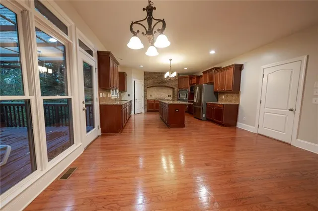 a view of a living room and kitchen with stainless steel appliances