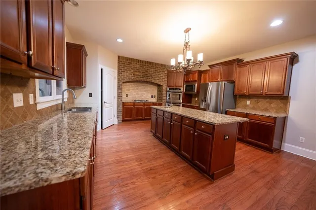 a large kitchen with stainless steel appliances wooden floors and wooden cabinets