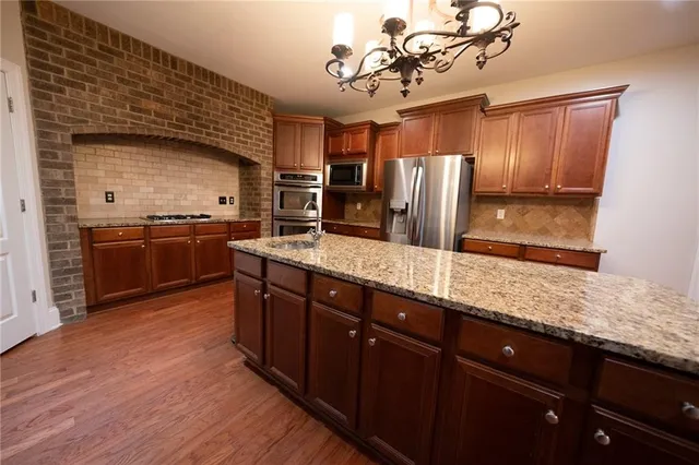 a large kitchen with stainless steel appliances granite countertop a sink and stove
