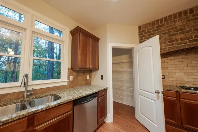 a kitchen with granite countertop a sink and a refrigerator