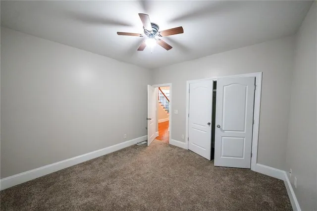 an empty room with closet and fan