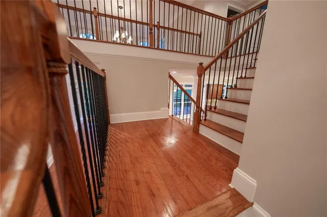a view of staircase with railing and a chandelier