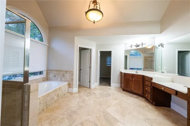 a large bathroom with a tub sink shower and mirror