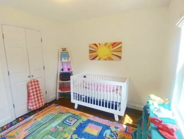 a bedroom with baby bed toys and paintings on the wall