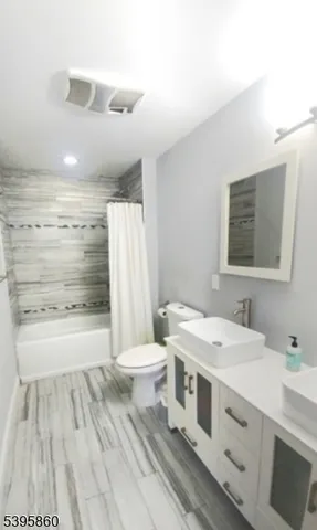 a bathroom with a double vanity sink toilet and shower