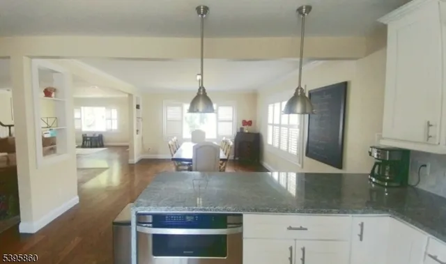 a view of a kitchen with a sink a counter space and wooden floor
