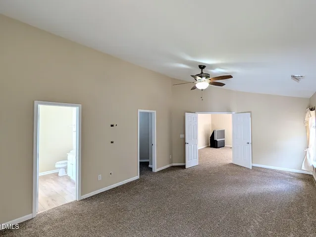 a view of a room with a ceiling fan and a bathroom