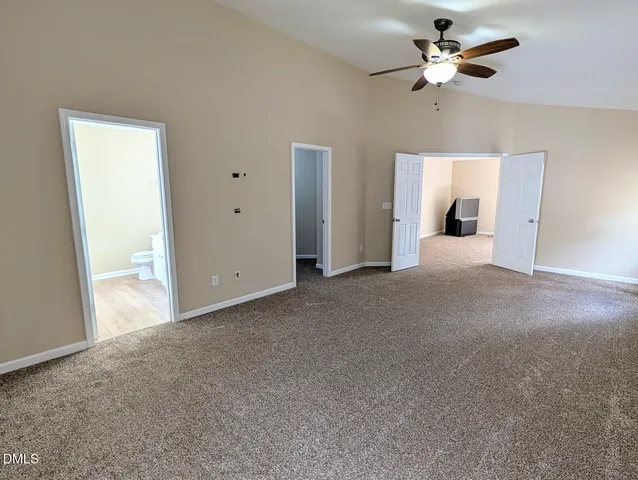 a view of a big room with chandelier fan and windows