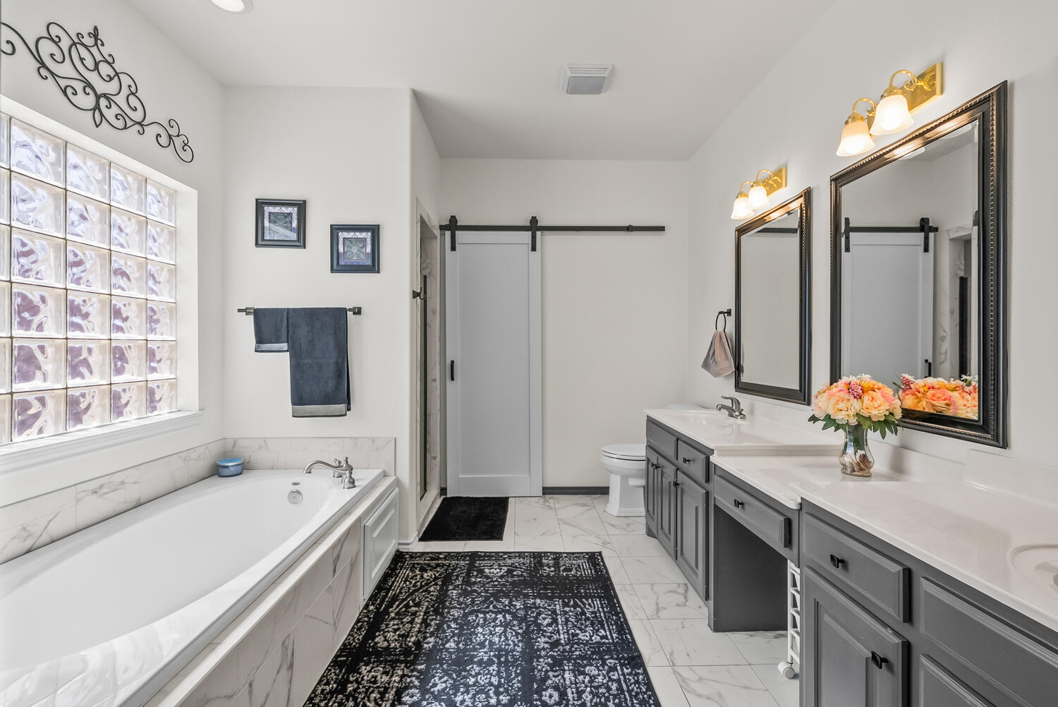 10508 Elgin Avenue Lubbock, TX 79423 - Photo 15 of 29 a bathroom with a double vanity sink a mirror and a bathtub