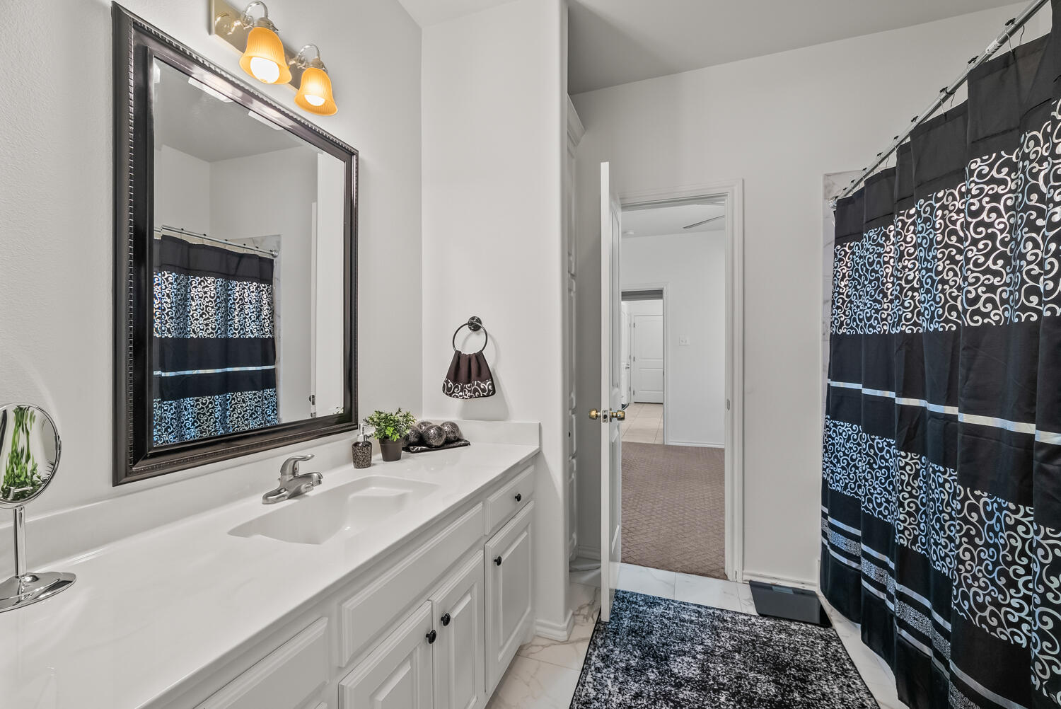 10508 Elgin Avenue Lubbock, TX 79423 - Photo 21 of 29 a bathroom with a sink a mirror and a shower