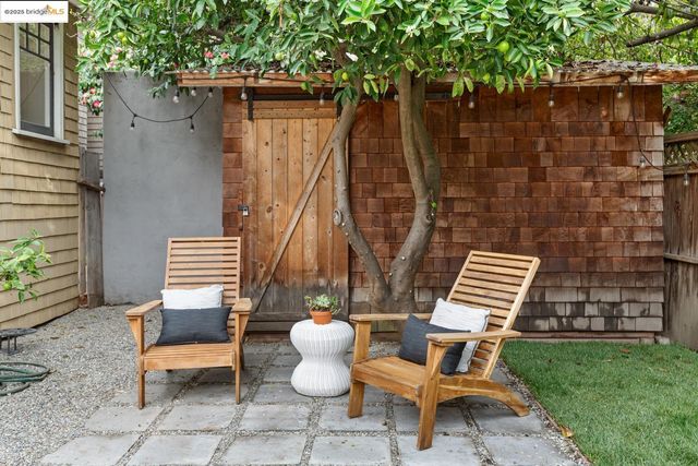 a view of a patio with table and chairs and potted plants with wooden fence