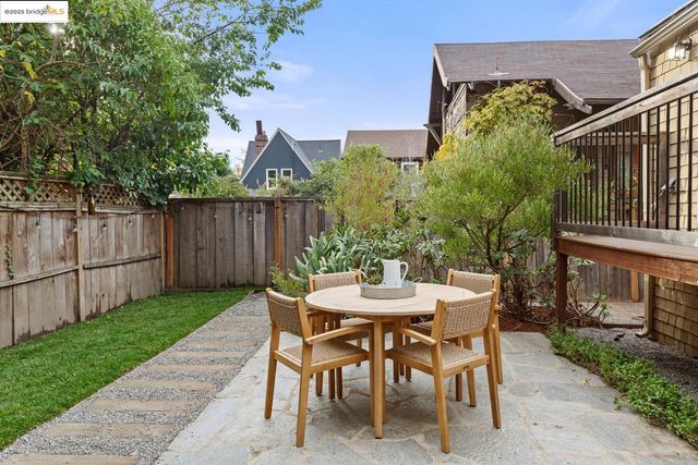 a view of a patio with table and chairs and wooden fence