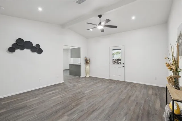 a view of empty room with wooden floor and window