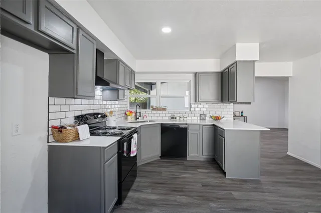 a kitchen with a sink cabinets and wooden floor