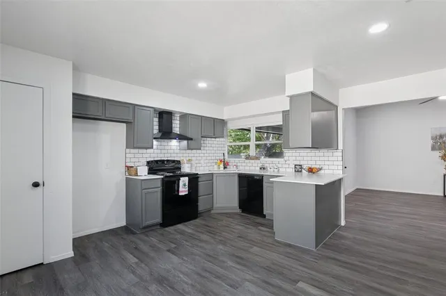 a kitchen with stainless steel appliances a sink dishwasher a refrigerator a stove top oven a oven with wooden floor