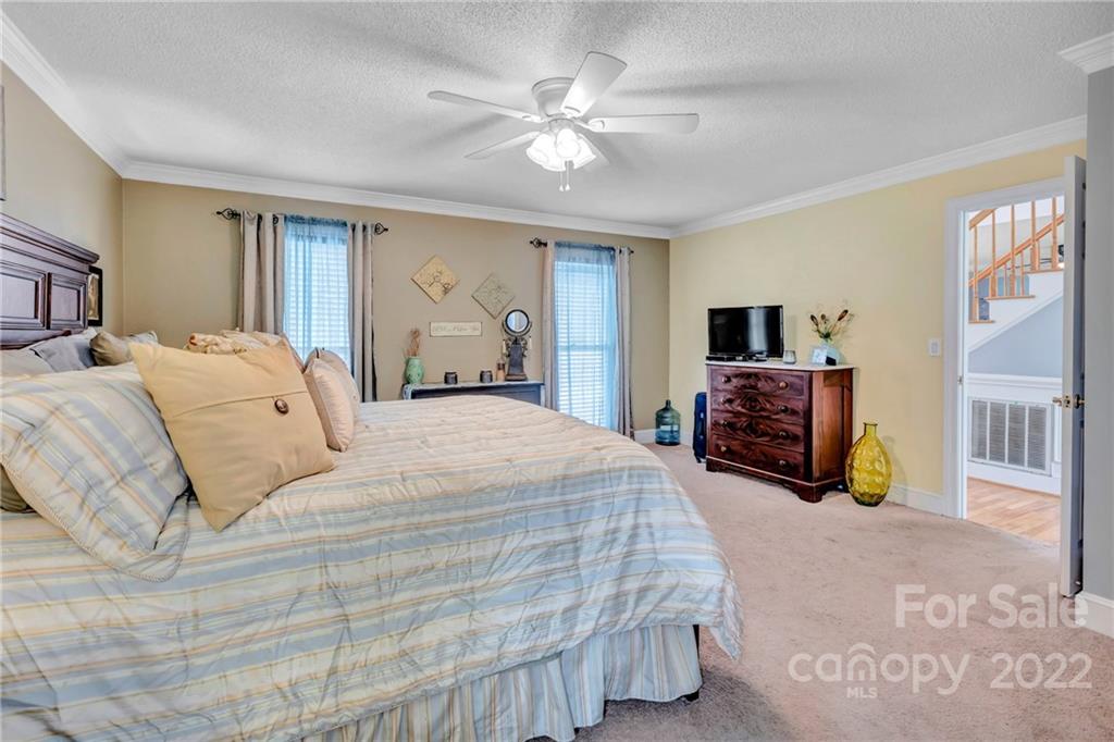 331 Polk Ford Road Stanfield, NC 28163 - Photo 18 of 47 a bedroom with a bed dresser and flat screen tv