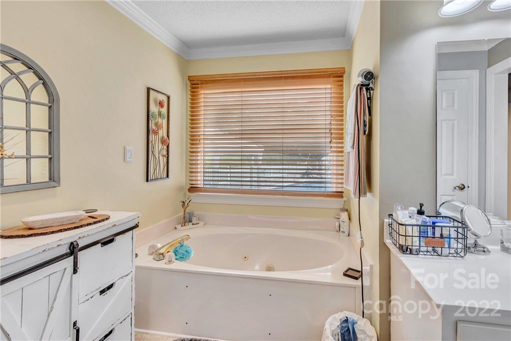 331 Polk Ford Road Stanfield, NC 28163 - Photo 20 of 47 a bathroom with a tub a sink and a window