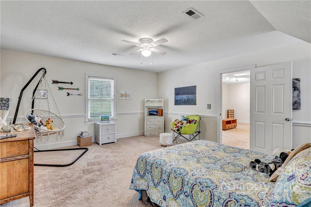331 Polk Ford Road Stanfield, NC 28163 - Photo 39 of 47 a bedroom with a bed and a chandelier
