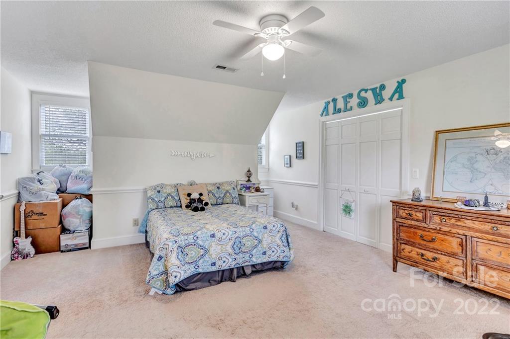 331 Polk Ford Road Stanfield, NC 28163 - Photo 40 of 47 a bedroom with a bed and a chandelier