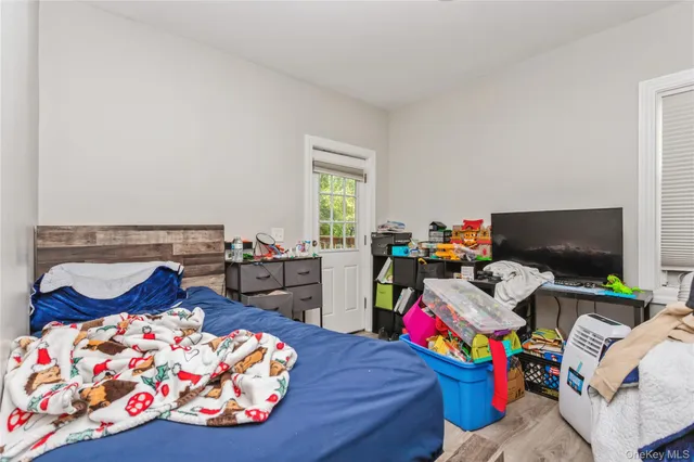 a bedroom with bed and a tv on the dresser