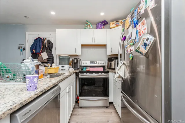 a kitchen with granite countertop a refrigerator and a sink