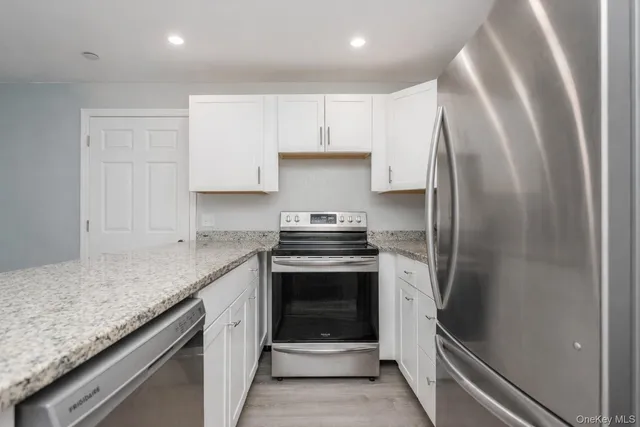 a kitchen with stainless steel appliances granite countertop a refrigerator and a stove