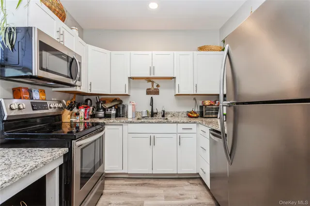 a kitchen with stainless steel appliances granite countertop a refrigerator stove top oven and sink