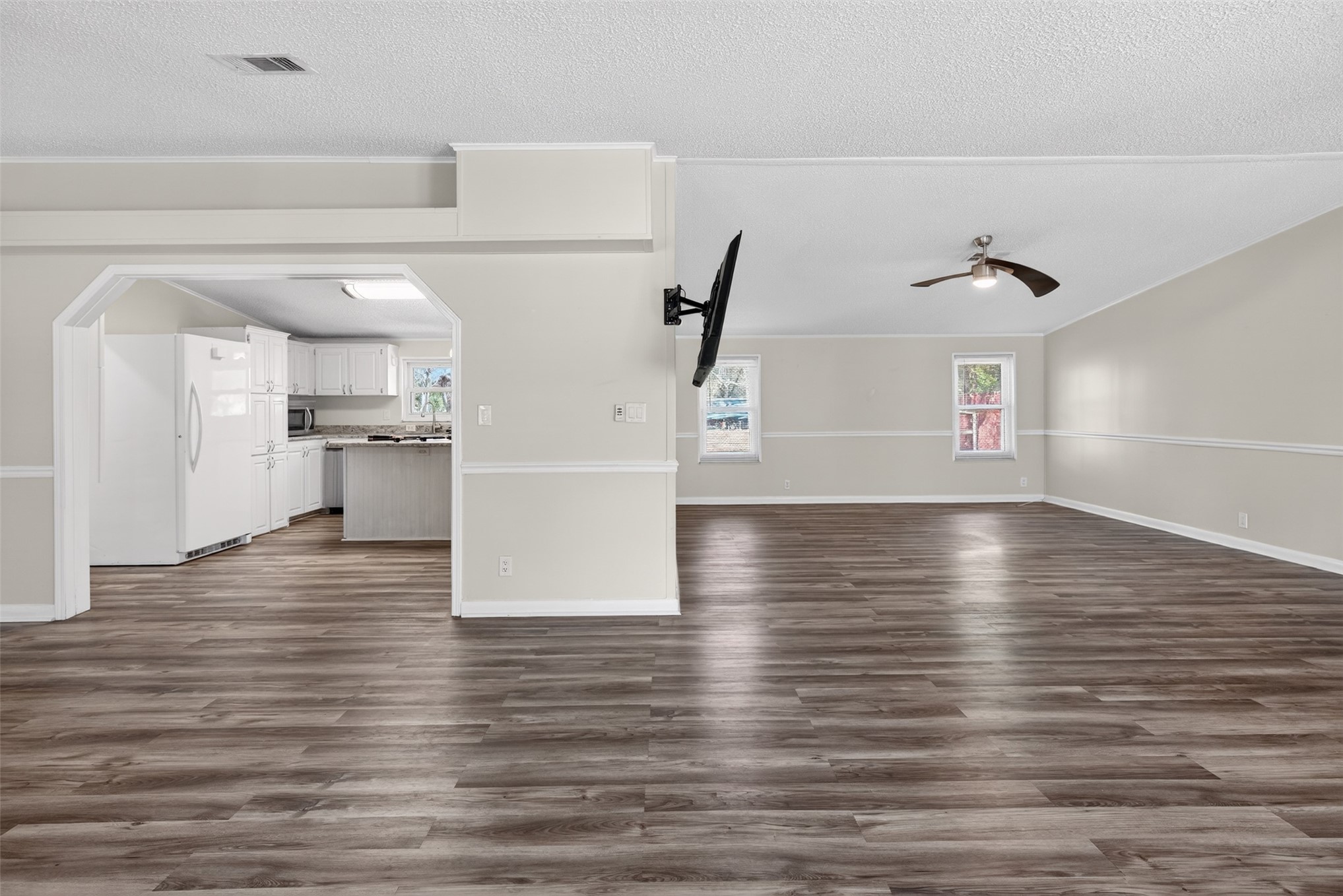 95021 Raintree Lane Fernandina Beach, FL 32034 - Photo 13 of 36 a view of a kitchen with kitchen island a sink wooden floor and a refrigerator