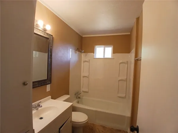 a bathroom with a bathtub shower sink vanity and toilet