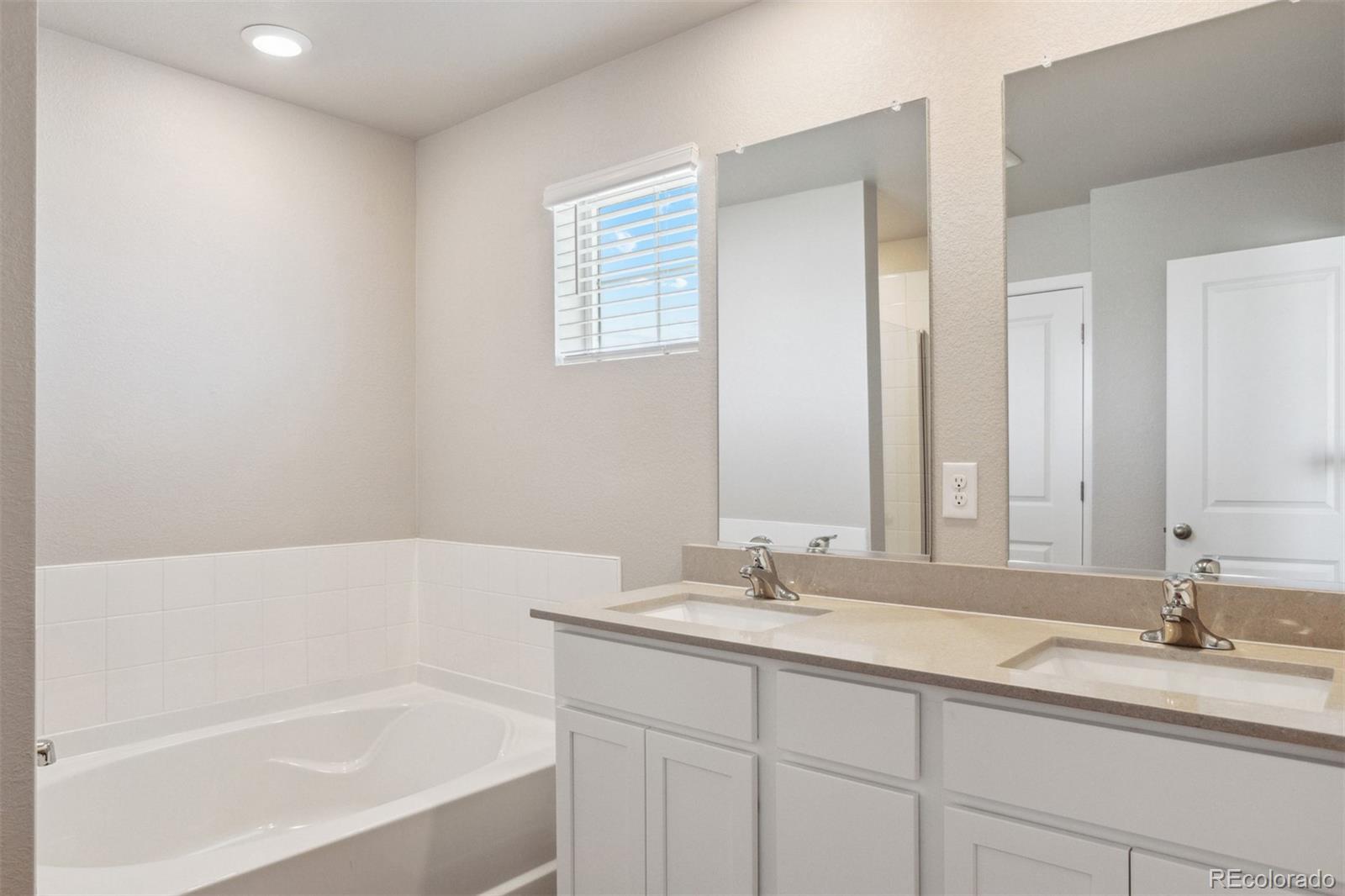 7416 Poudre Street Frederick, CO 80530 - Photo 11 of 30 a bathroom with a tub sink and mirror