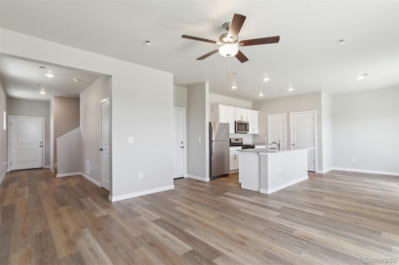 7416 Poudre Street Frederick, CO 80530 - Photo 8 of 30 a view of a kitchen with wooden floor and a ceiling fan
