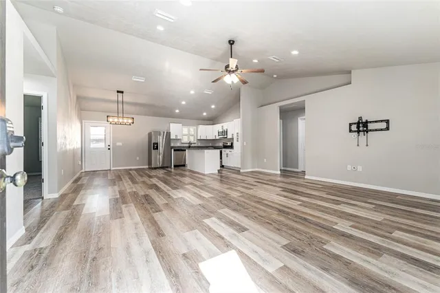 a view of a livingroom with a ceiling fan kitchen view and a ceiling fan