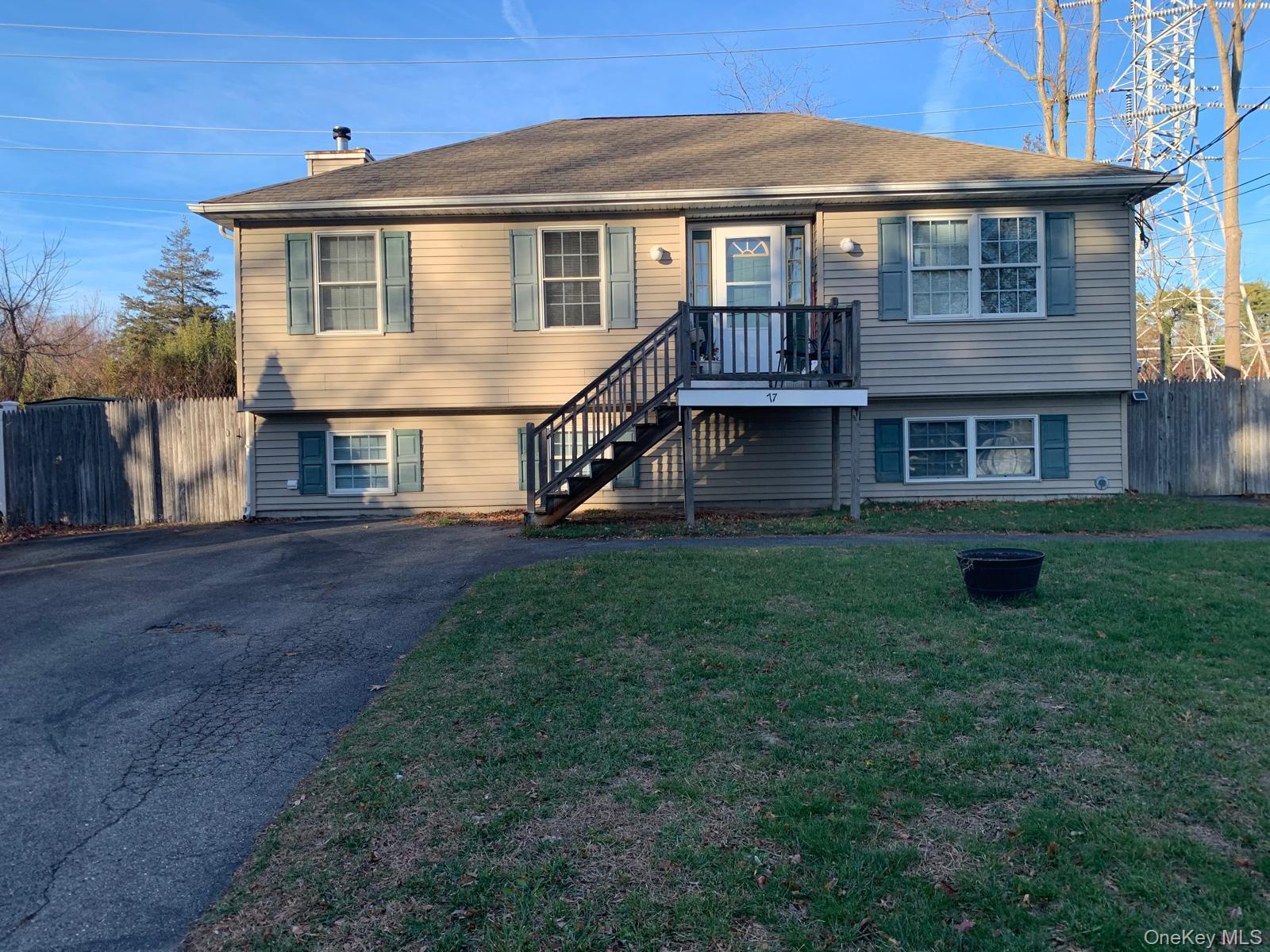 View of front of property featuring a chimney, asphalt driveway, and stairs