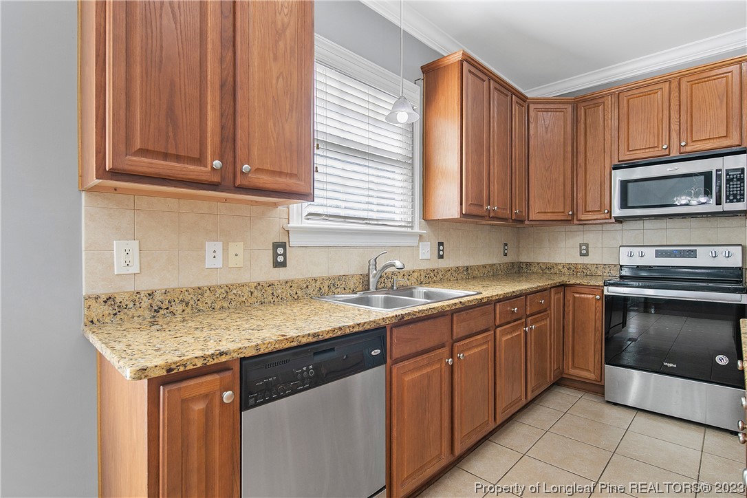 115 Blue Pine Drive Spring Lake, NC 28390 - Photo 14 of 48 a kitchen with granite countertop a sink dishwasher stove and cabinets with wooden floor