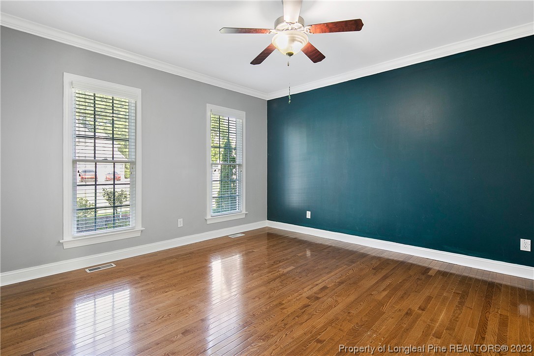 115 Blue Pine Drive Spring Lake, NC 28390 - Photo 17 of 48 an empty room with wooden floor chandelier fan and windows