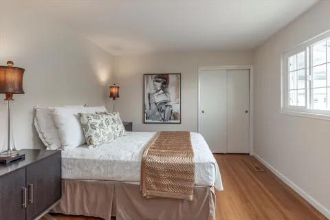 a bedroom with a bed and wooden floor