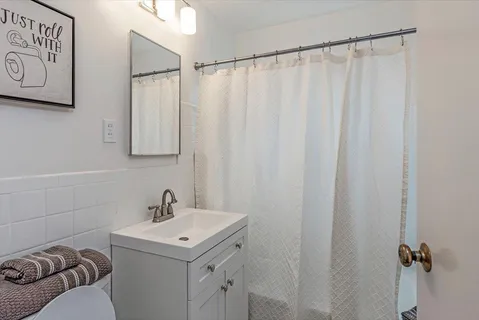 a bathroom with a sink a vanity and a shower curtain
