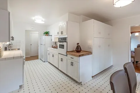 a kitchen with white cabinets and white appliances