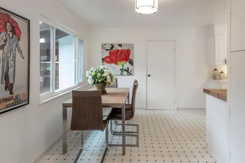 a dining room with furniture and a potted plant
